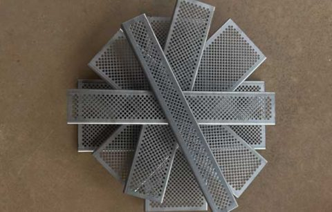 This is a picture of perforated grates stacked on one another. They are gray in color.