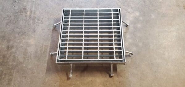 A metal grate sitting on top of the ground.