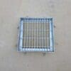 A metal grate sitting on top of the ground.