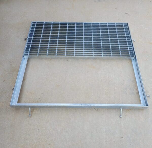 A metal grate sitting on top of the ground.