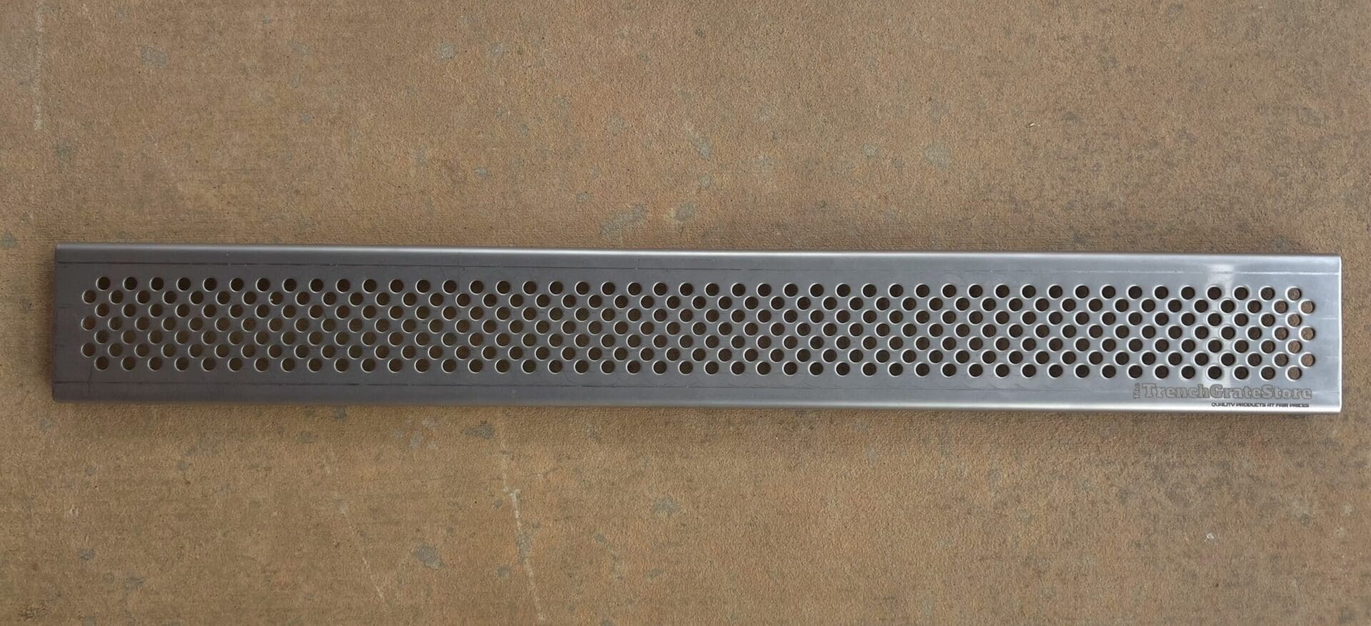 A metal bar with holes in it on the floor.