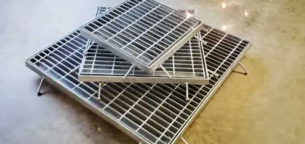 A group of three metal grates on the floor.