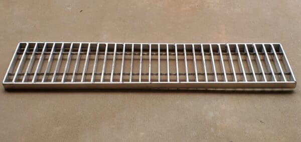 A metal shelf with bars on top of it.