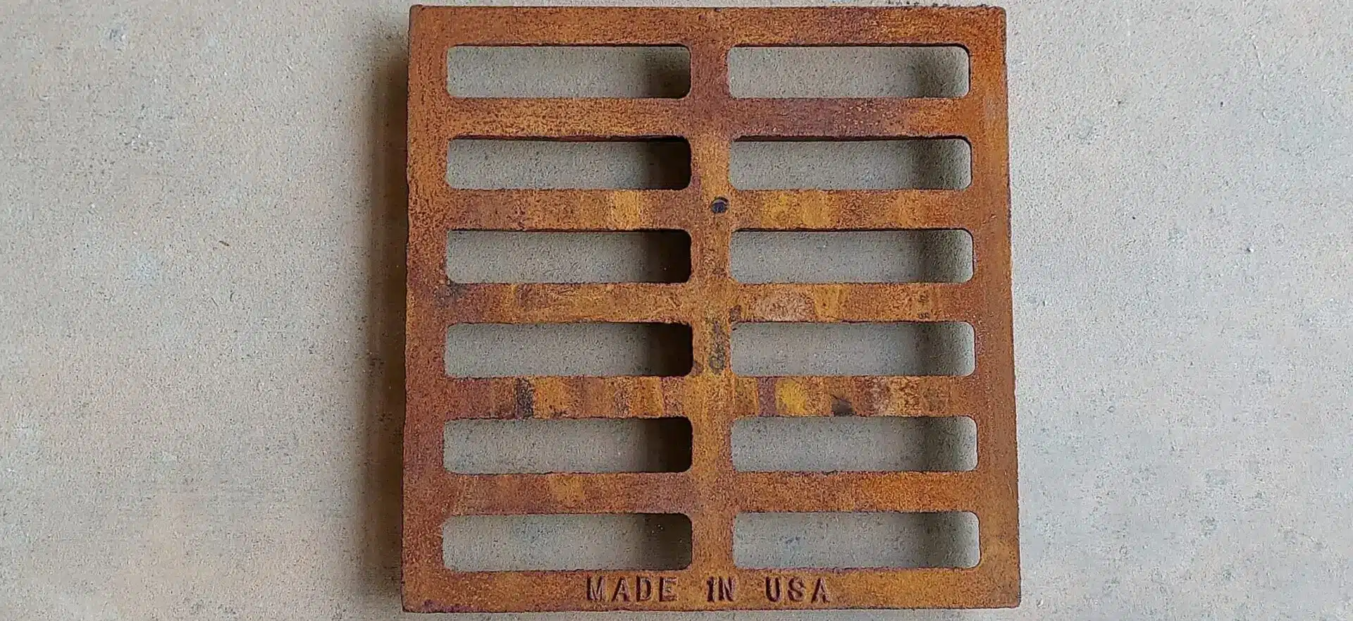 A rusty metal grate with the made in usa logo.