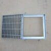 A metal grate with a square frame on top of it.