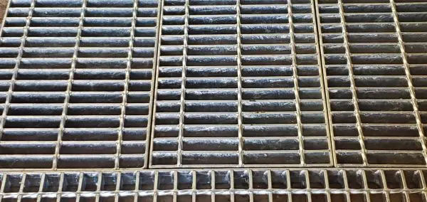 A close up of the bottom of a metal grate.