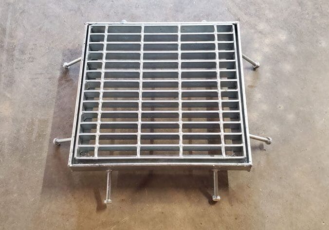 A metal grate sitting on top of the ground.