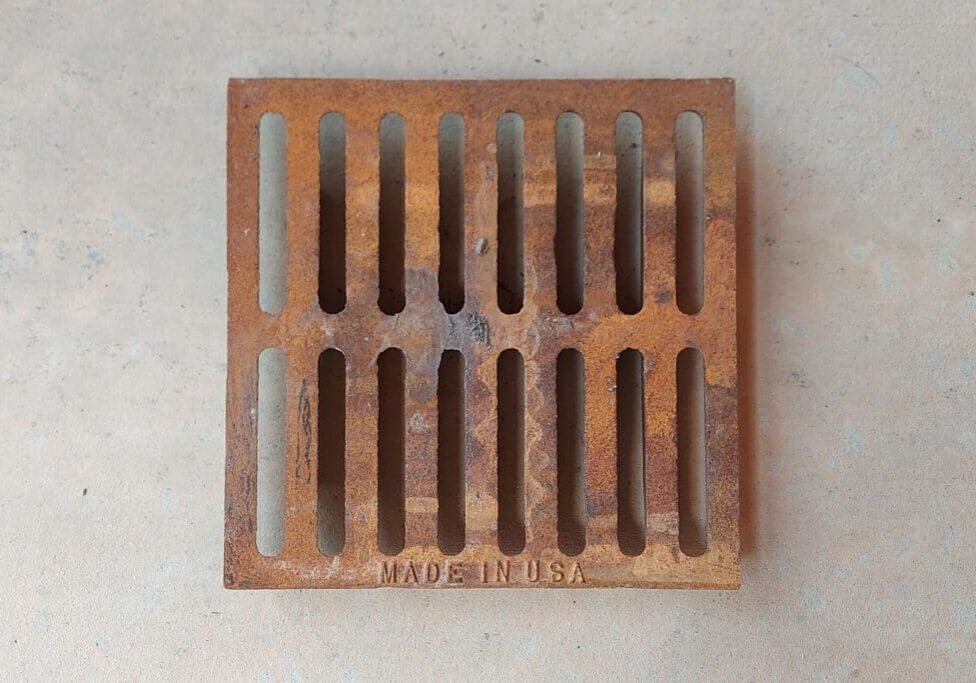Rusty metal drain grate, Made in USA.