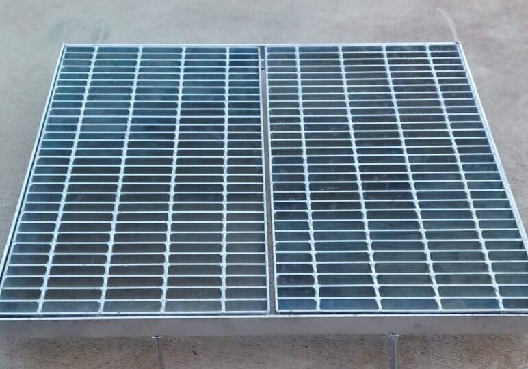 A metal grate that is on the ground.