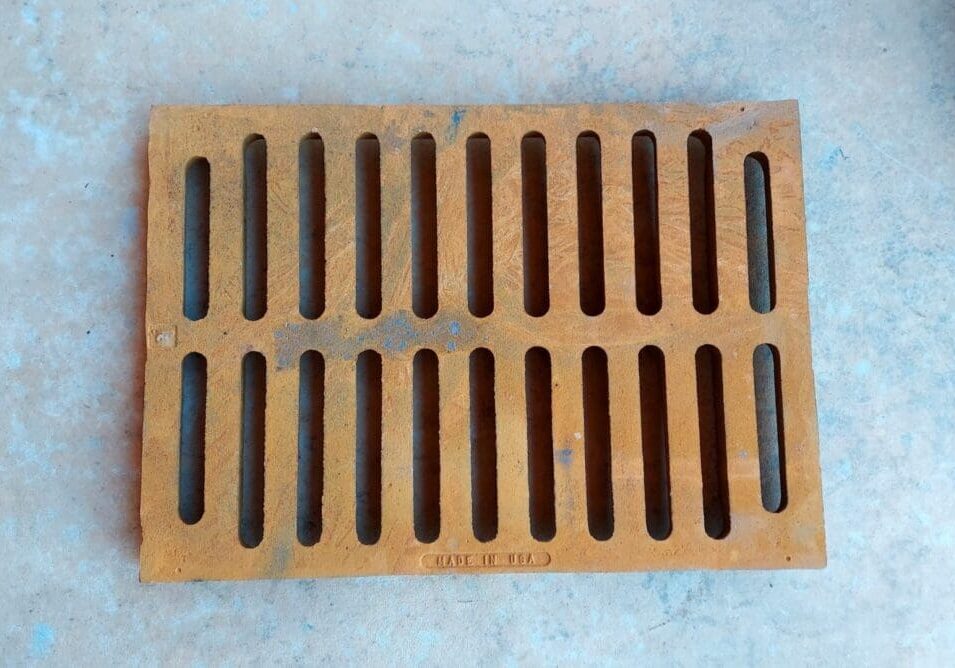 A brown grate sitting on top of a floor.