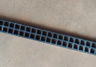 A close up of the bottom of a blue plastic fence.