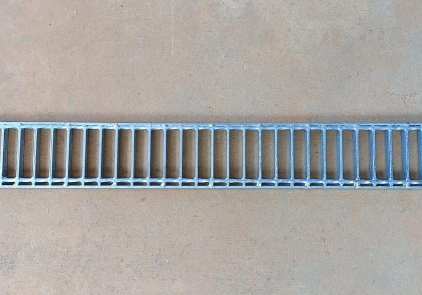 A metal grate that is on the ground.